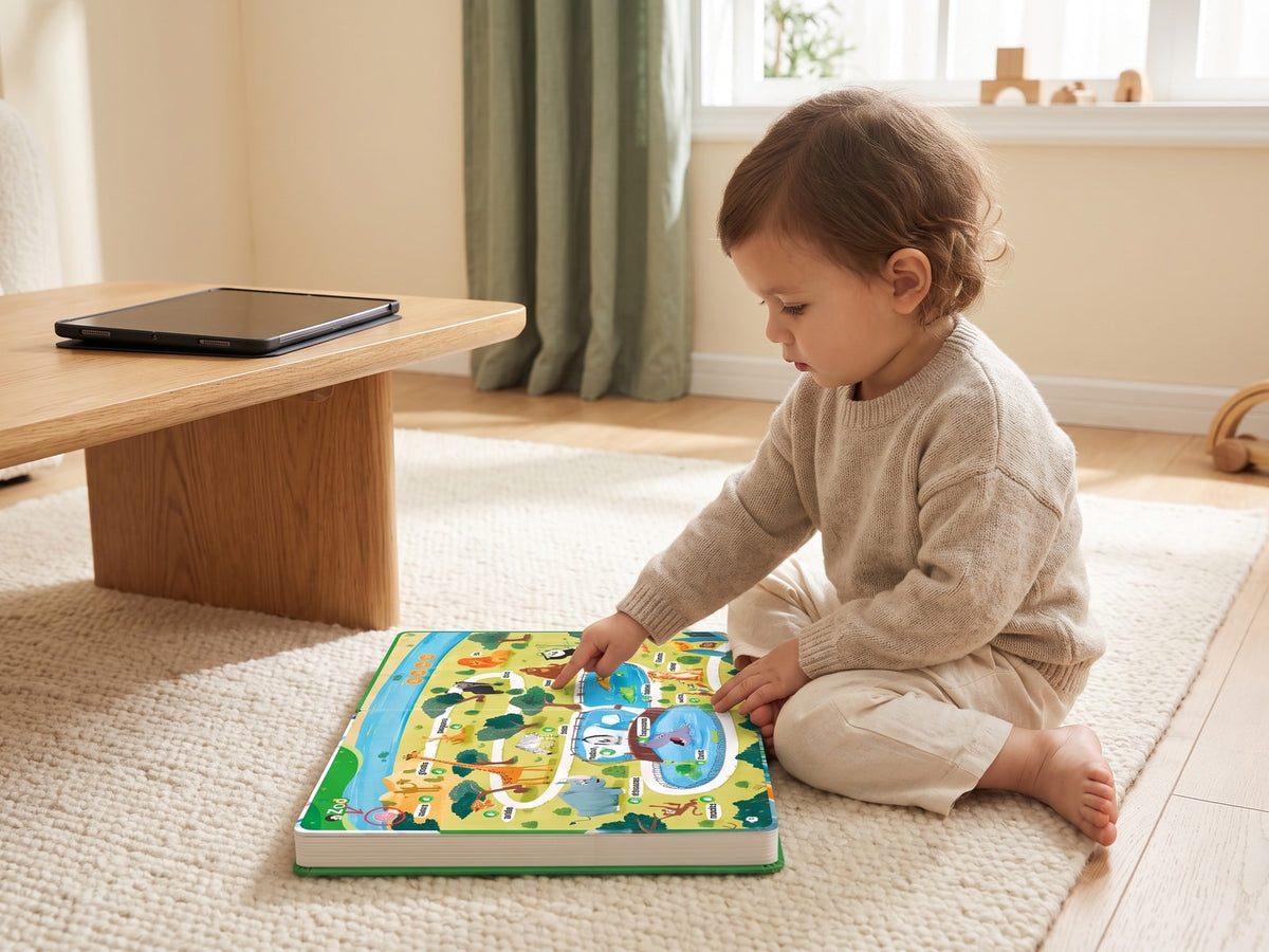 Toddler on the floor with the Velledo sound book open in front of her